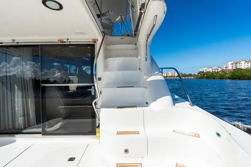  Yacht Photos Pics 2003 Sea Ray 560 Sedan Bridge yacht with stairs, water view, and clear blue sky.