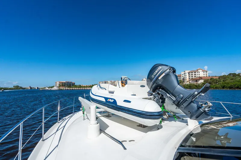  Yacht Photos Pics 2003 Sea Ray 560 Sedan Bridge yacht with inflatable boat on deck, scenic waterfront view.