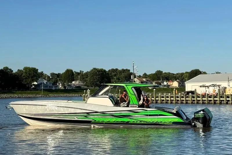  Yacht Photos Pics 2024 Deep Impact 399 Sport boat with vibrant green accents on calm water.