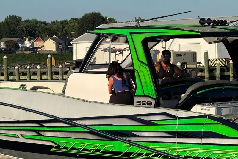  Yacht Photos Pics 2024 Deep Impact 399 Sport boat docked, featuring vibrant green accents and sleek design.