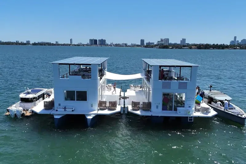 The Myth Yacht Photos Pics Floating ARKHAUS Villa 50, 2025 model, on water with city skyline in background.