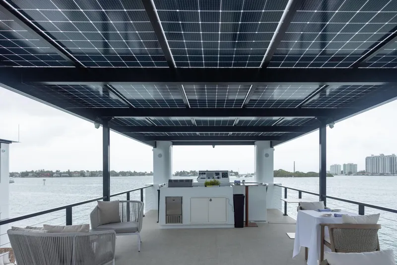 The Myth Yacht Photos Pics Modern ARKHAUS Villa 50 houseboat with solar panels, elegant seating, and waterfront view, 2025 model.