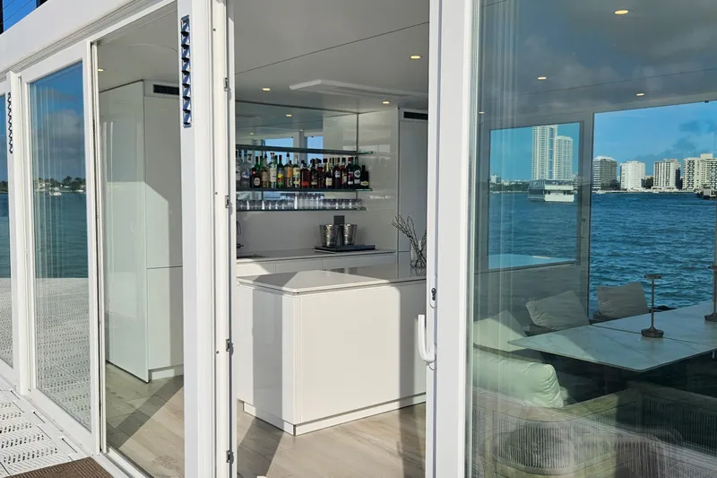 The Myth Yacht Photos Pics Floating ARKHAUS Villa 50 interior with modern bar, overlooking waterfront cityscape, 2025 model.