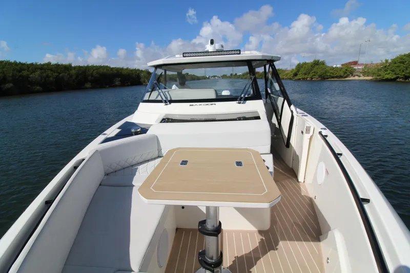  Yacht Photos Pics 2025 Saxdor 400 GTS boat interior with table, cruising on a scenic waterway.
