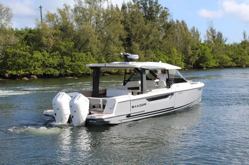  Yacht Photos Pics 2025 Saxdor 400 GTS boat cruising on a scenic river with lush greenery.