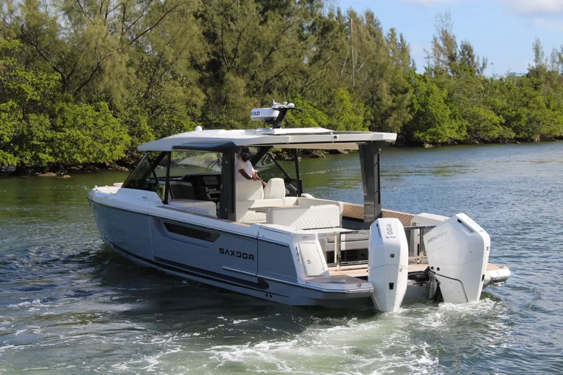  Yacht Photos Pics 2025 Saxdor 400 GTS boat cruising on a scenic waterway with lush greenery.