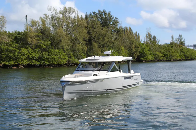  Yacht Photos Pics 2025 Saxdor 400 GTS cruising on a scenic waterway with lush greenery.