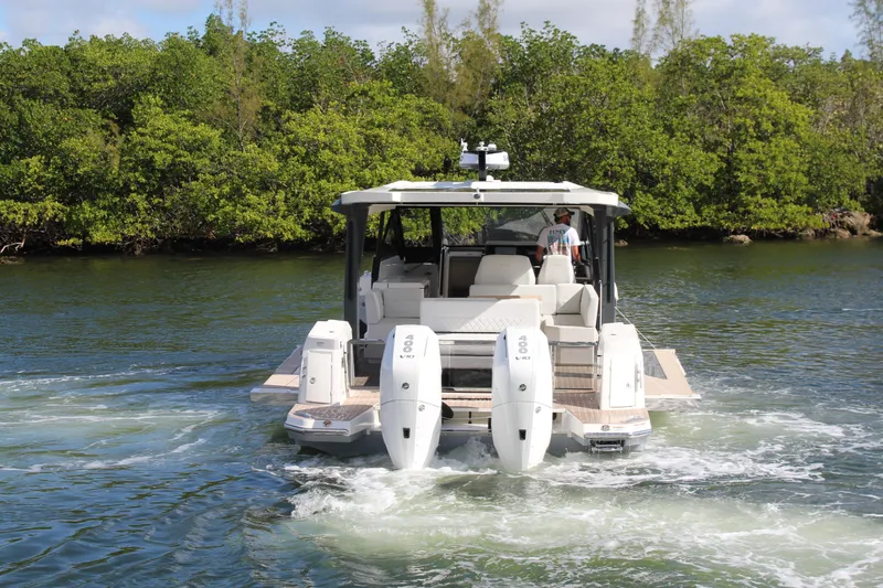  Yacht Photos Pics 2025 Saxdor 400 GTS boat cruising on a scenic waterway with lush greenery.