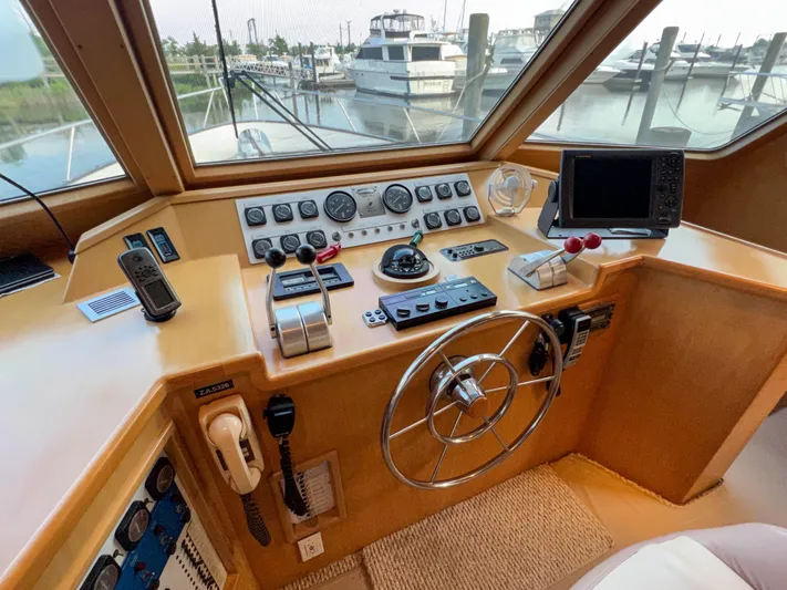 Audacious Yacht Photos Pics Southern Cross 53 yacht helm, 1986 model, featuring navigation controls and marina view.