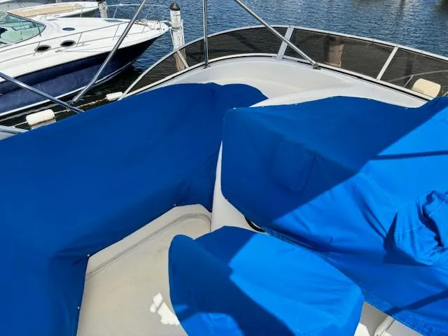  Yacht Photos Pics 2004 Meridian Sedan Bridge 341 with blue covers on deck, docked by the water.