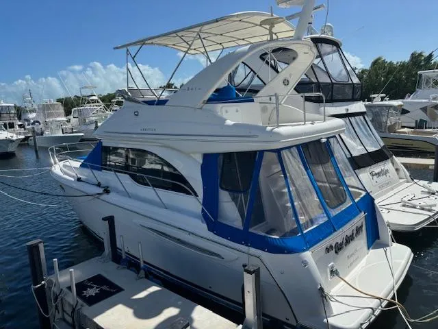  Yacht Photos Pics 2004 Meridian Sedan Bridge 341 docked at marina, featuring blue accents and spacious upper deck.