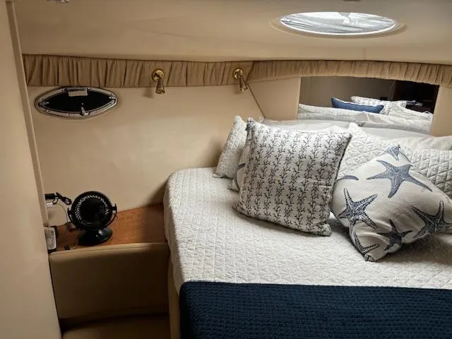  Yacht Photos Pics Cozy cabin interior of 2004 Meridian Sedan Bridge 341 with nautical-themed bedding.
