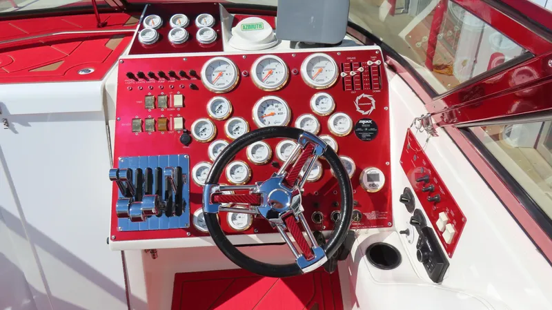  Yacht Photos Pics 2002 Fountain 47 Lightning boat dashboard with red and white gauges and steering wheel.