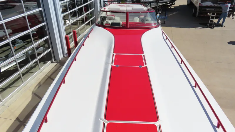  Yacht Photos Pics 2002 Fountain 47 Lightning boat with red and white design, docked near a building.