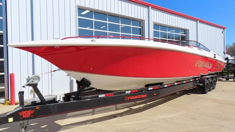  Yacht Photos Pics Red 2002 Fountain 47 Lightning boat on trailer, parked outside a building.