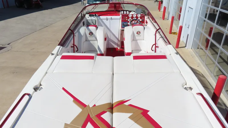  Yacht Photos Pics 2002 Fountain 47 Lightning boat with red and white interior, docked near a building.