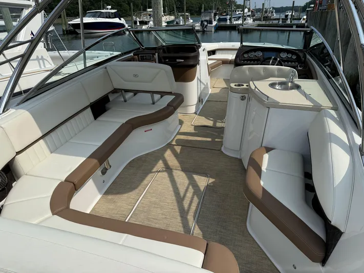  Yacht Photos Pics 2015 Cobalt 302 boat interior with white and brown seating, docked at a marina.