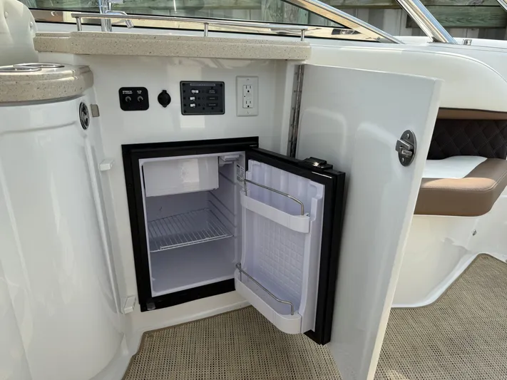  Yacht Photos Pics Open mini fridge on 2015 Cobalt 302 boat, showcasing interior storage and control panel.