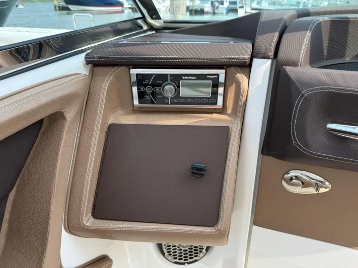  Yacht Photos Pics Cobalt 302 boat interior with stereo system, brown leather accents, and chrome handle, 2015 model.