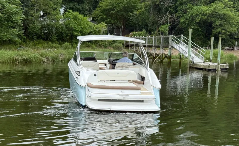  Yacht Photos Pics 2015 Cobalt 302 boat navigating a calm river near a dock and lush greenery.