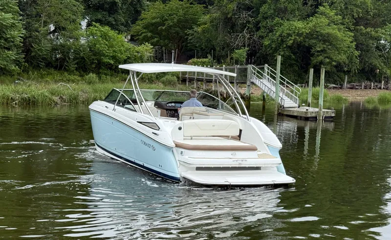  Yacht Photos Pics Cobalt 302 boat from 2015 cruising on a calm river near a dock.
