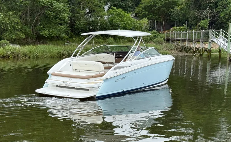  Yacht Photos Pics 2015 Cobalt 302 boat on a calm river near lush greenery.