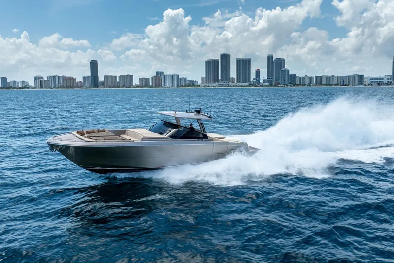 Spin Yacht Photos Pics 2019 CNM Continental 54 yacht cruising on ocean with city skyline backdrop.