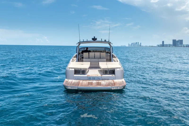 Spin Yacht Photos Pics Luxury CNM Continental 54 yacht cruising on open sea, city skyline in background.