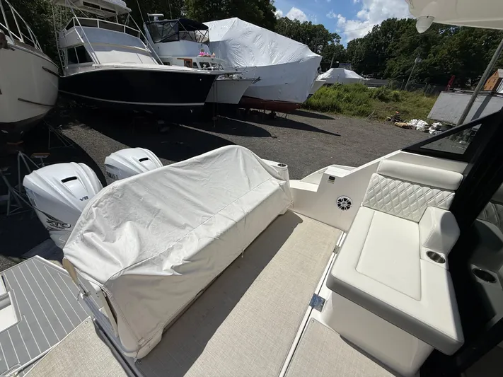  Yacht Photos Pics 2022 Regal 36 XO boat interior with covered seating and twin outboard engines.
