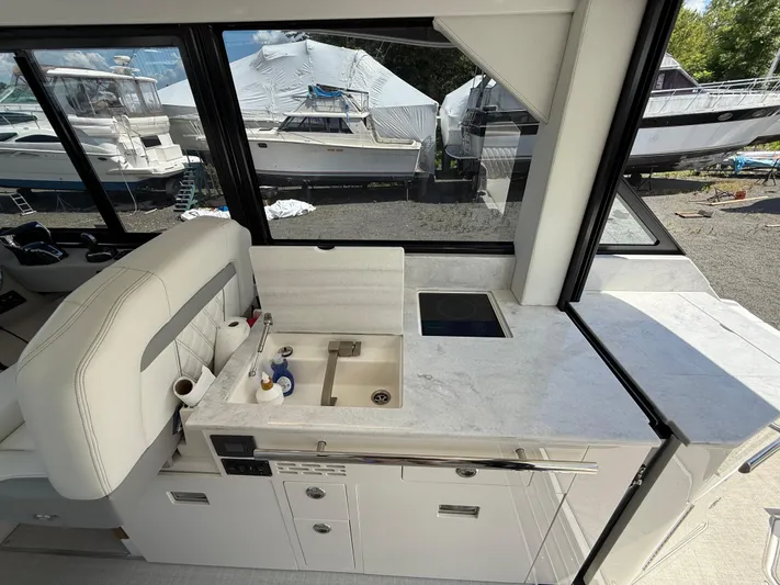  Yacht Photos Pics 2022 Regal 36 XO yacht interior with modern kitchenette and scenic marina view.