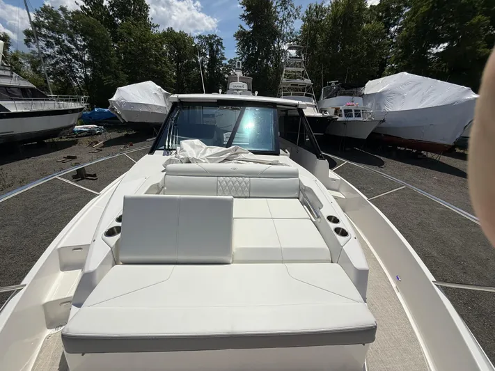  Yacht Photos Pics 2022 Regal 36 XO yacht with spacious deck, surrounded by other boats in a marina.