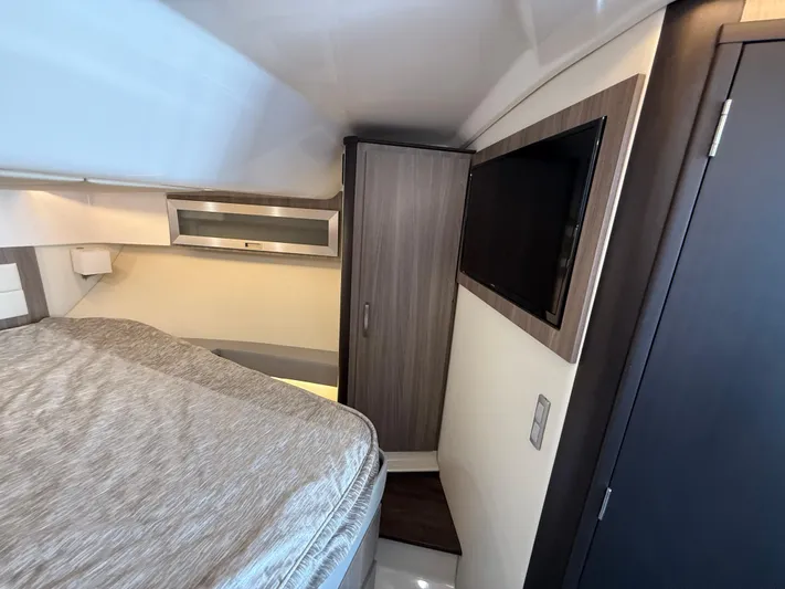 Yacht Photos Pics 2022 Regal 36 XO cabin interior with bed, wardrobe, and wall-mounted TV.