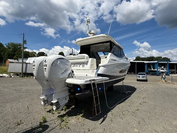  Yacht Photos Pics 2022 Regal 36 XO boat with twin Yamaha engines, parked outdoors under a cloudy sky.