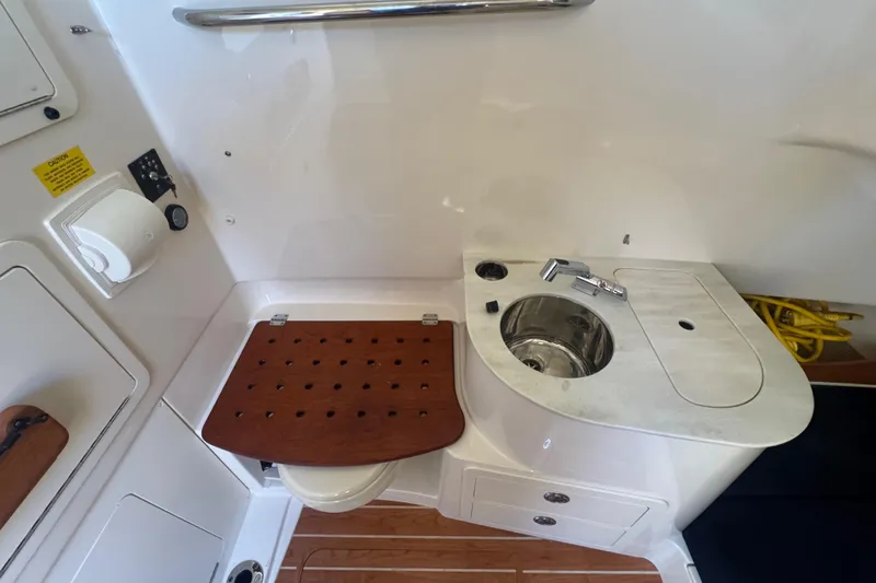 Your New Boat! Yacht Photos Pics 2024 Grady-White Canyon 336 boat interior with sink and wooden seat.