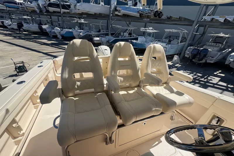 Your New Boat! Yacht Photos Pics 2024 Grady-White Canyon 336 boat with luxurious seating and steering wheel in a marina.