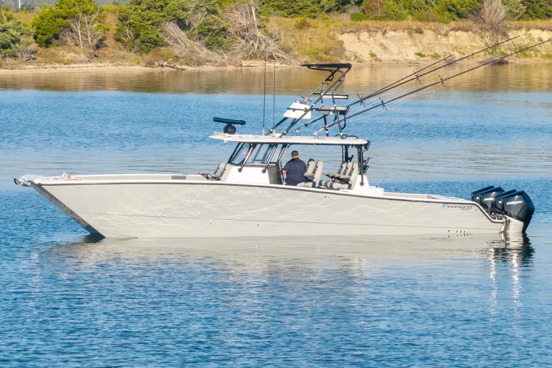  Yacht Photos Pics 2022 Freeman 42 LR boat on calm water with fishing rods and outboard motors.