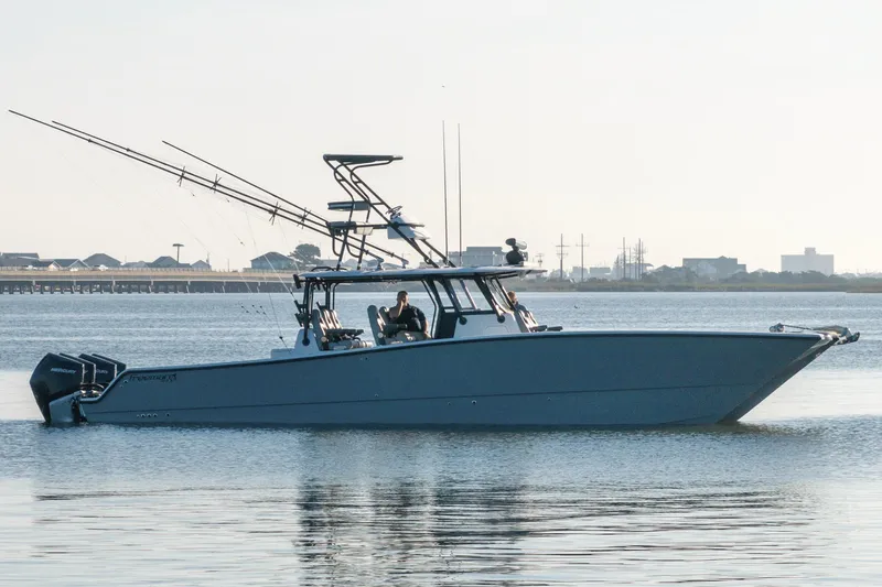  Yacht Photos Pics 2022 Freeman 42 LR boat on calm water, equipped with multiple fishing rods.