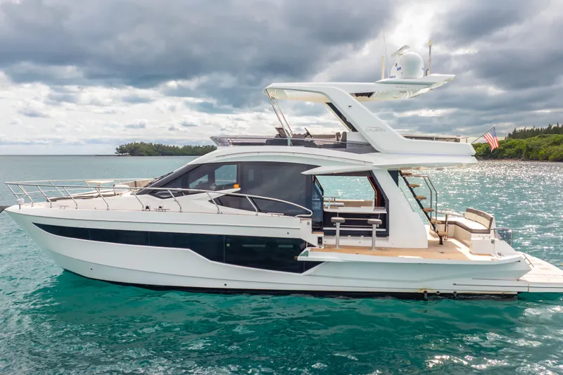 Infinity Yacht Photos Pics 2020 Galeon 500 Fly yacht on turquoise water under cloudy sky.