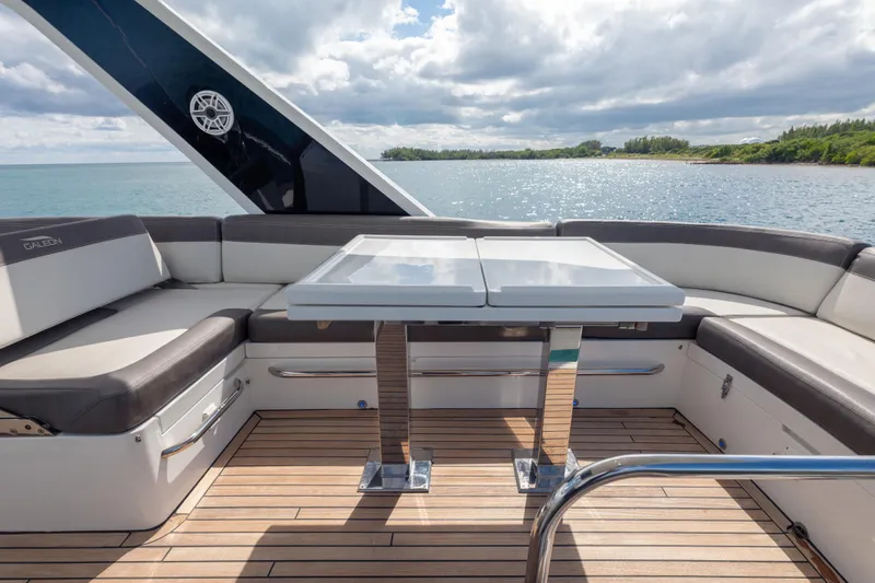 Infinity Yacht Photos Pics Luxurious 2020 Galeon 500 Fly yacht deck with seating and table, overlooking serene waters.