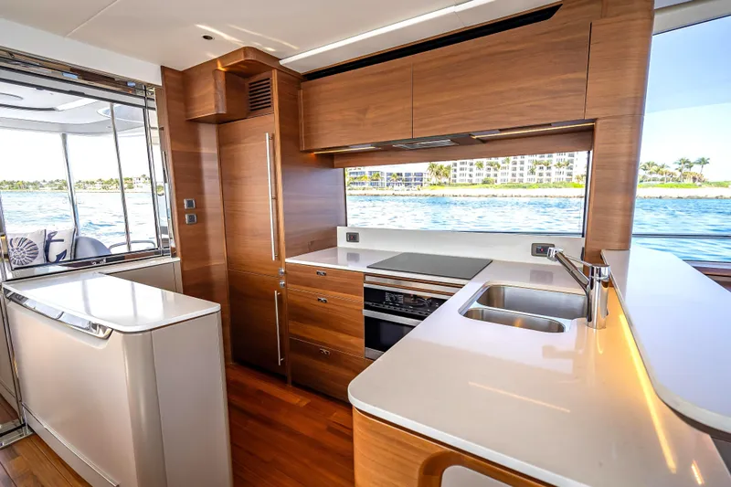 Iseablu Yacht Photos Pics Luxurious 2023 Princess Y72 yacht kitchen with modern wood cabinetry and ocean view.