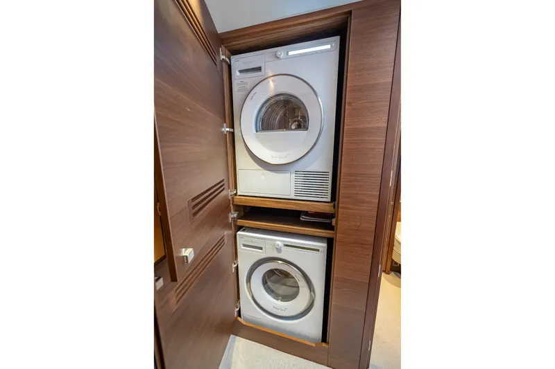 Iseablu Yacht Photos Pics Stacked washer and dryer in 2023 Princess Y72 yacht's wooden cabinet.