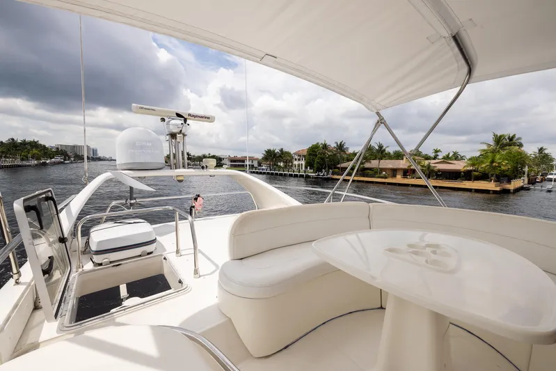 Sea Diva Yacht Photos Pics 1999 Azimut 58 yacht deck with seating, table, and waterway view.