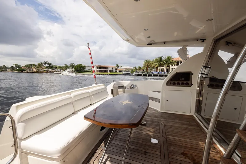 Sea Diva Yacht Photos Pics 1999 Azimut 58 yacht deck with seating and table, overlooking waterfront homes.