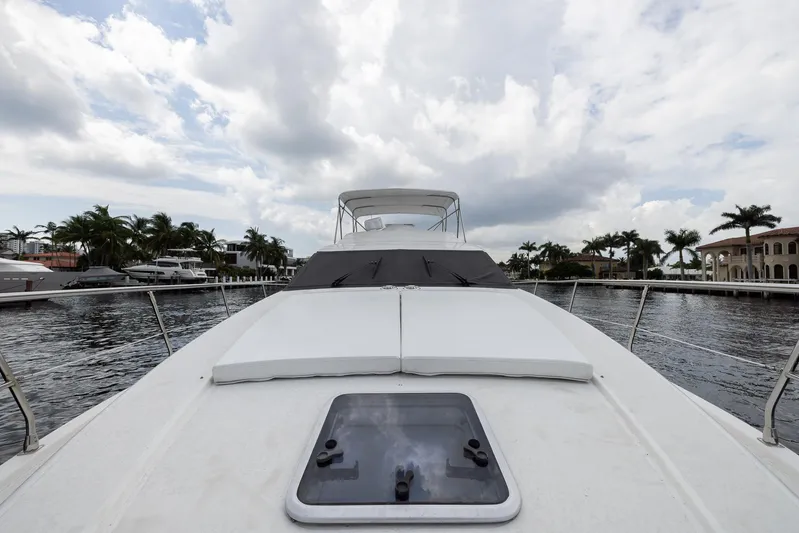 Sea Diva Yacht Photos Pics 1999 Azimut 58 yacht on water, cloudy sky, palm trees in background.