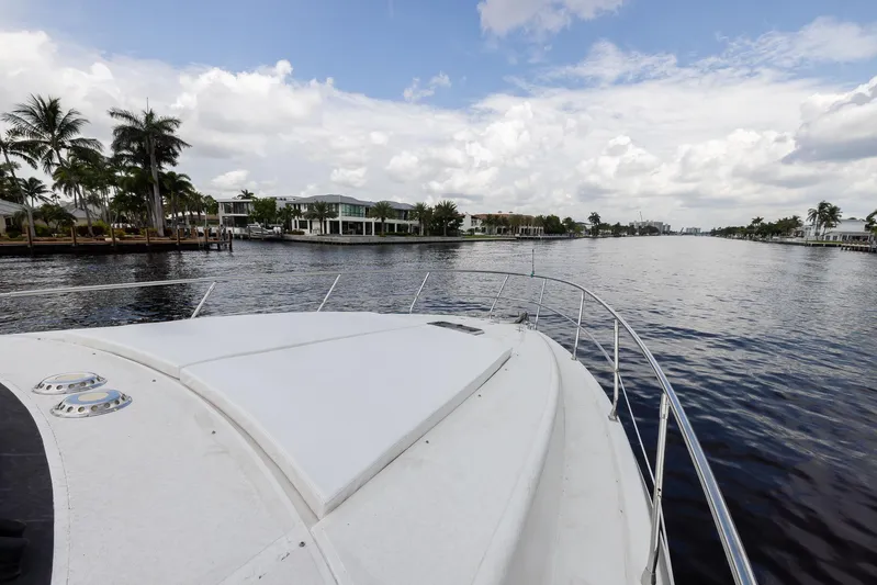 Sea Diva Yacht Photos Pics 1999 Azimut 58 yacht cruising on a scenic waterway with palm trees and luxury homes.