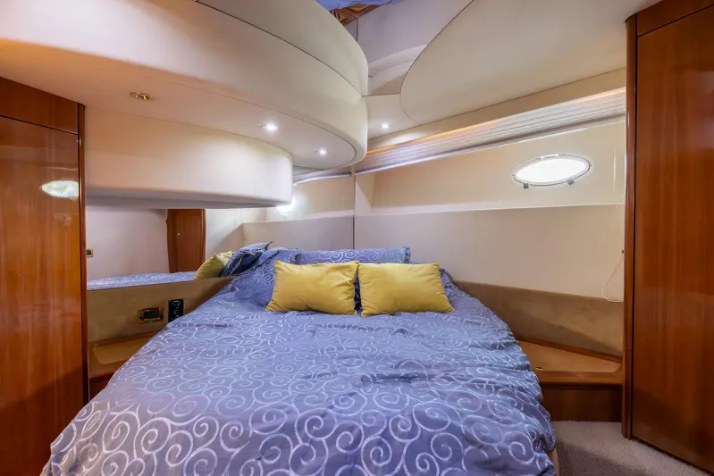 Sea Diva Yacht Photos Pics Luxurious bedroom interior of 1999 Azimut 58 yacht with blue bedding and wooden accents.