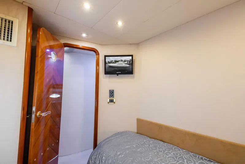 Sea Diva Yacht Photos Pics Cozy bedroom interior of 1999 Azimut 58 yacht with TV and wooden door.