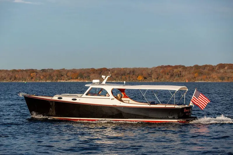 Drowsy Maggie Yacht Photos Pics 2000 Hinckley Picnic Boat Classic cruising on a serene lake with autumn foliage backdrop.