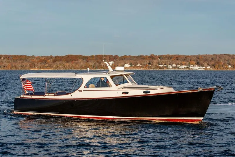 Drowsy Maggie Yacht Photos Pics 2000 Hinckley Picnic Boat Classic cruising on a serene lake with autumn foliage backdrop.