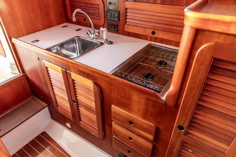 Drowsy Maggie Yacht Photos Pics Hinckley Ya Picn 2001 yacht kitchen with wooden cabinetry, sink, and stove.
